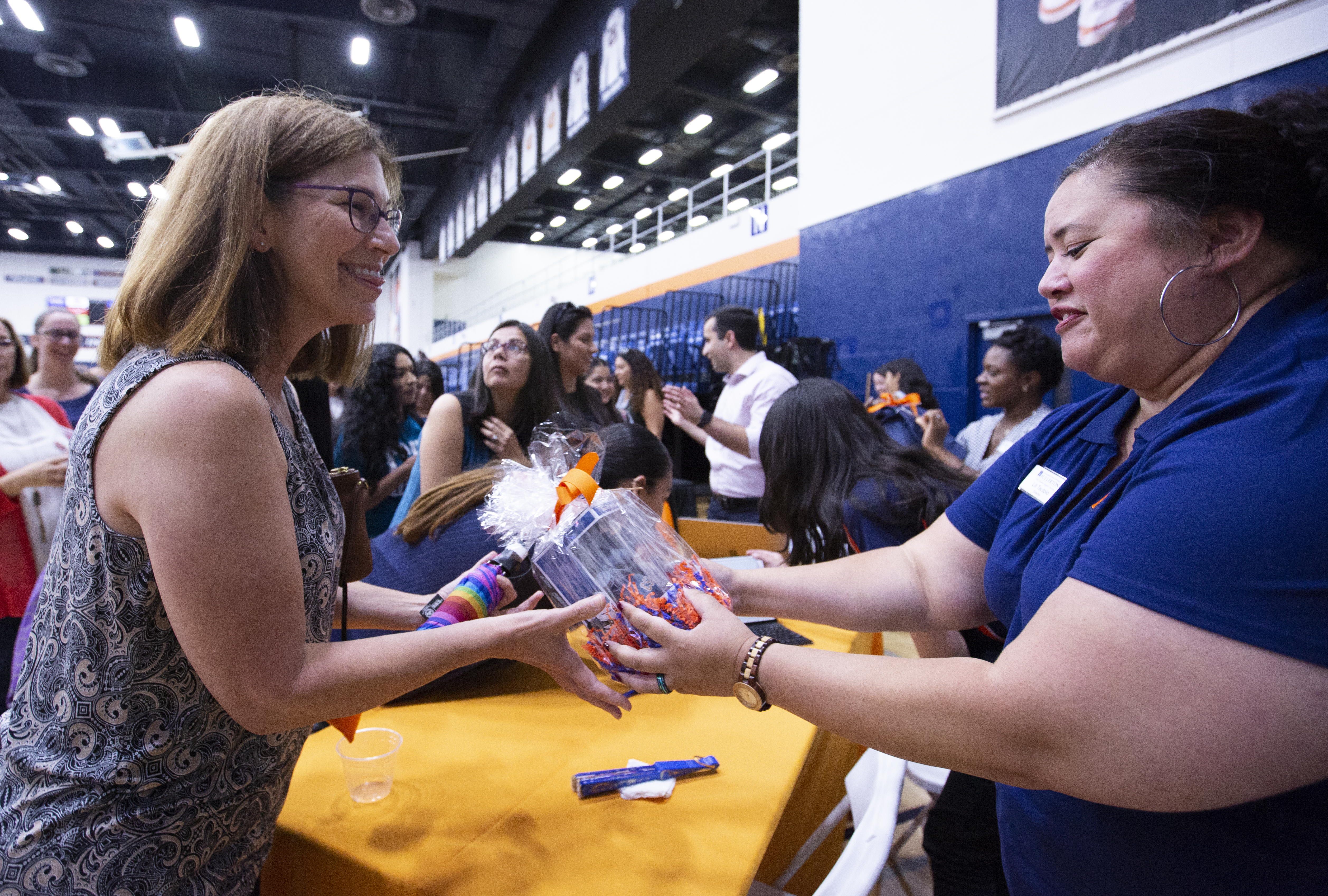a woman handing another woman a gift at an event