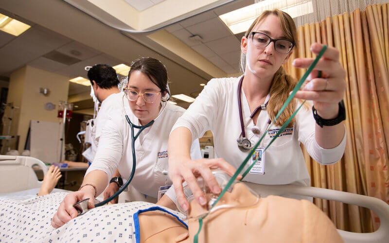 two nursing students hold stethoscope