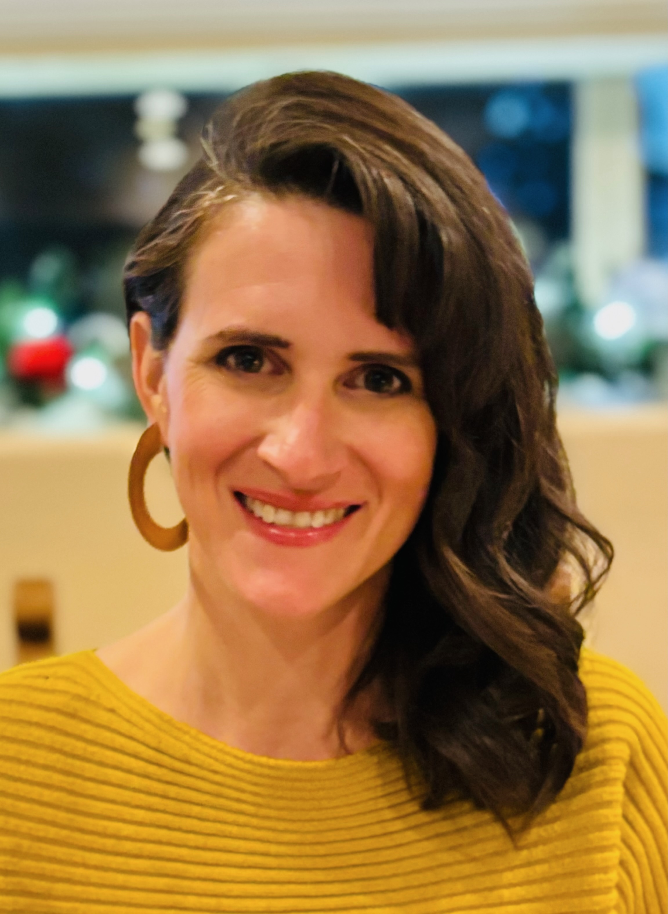 photograph of Brittany Franck showing a woman with long brown hair wearing a yellow shirt