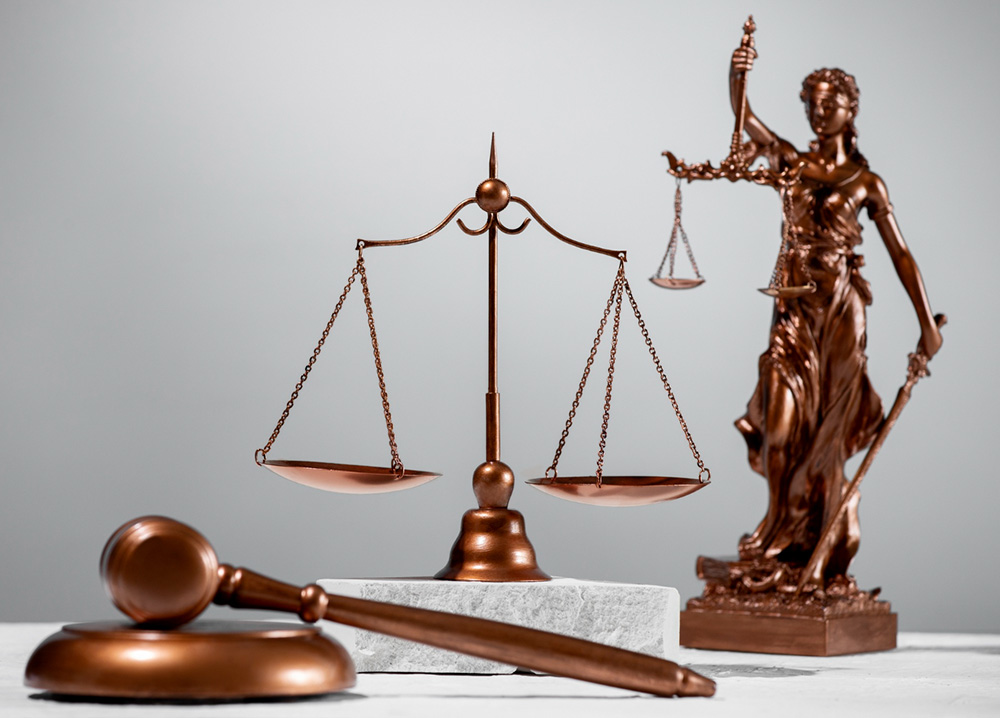 A statue of lady of justice holding a scale and a judicial hammer 