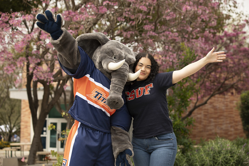 Student posing with Tuffy the school mascot
